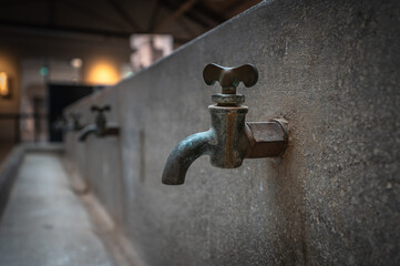 Historic faucet full of the trace of time, focus on the main subject, background out of focus in...