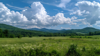 Puffy clouds over a green mountain landscape.
