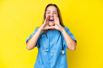 Young surgeon nurse woman isolated on yellow background shouting and announcing something