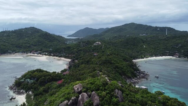 Drone flying above coast of Koh Tao in Thailand with view on ocean and hills with jungle and ocean