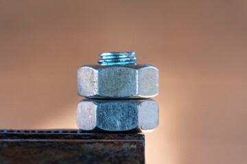 Two nuts screwed onto a bolt clamped in a vice, closeup. Using clamp to remove nut from bolt, macro. Industry and repair concept - 783627732