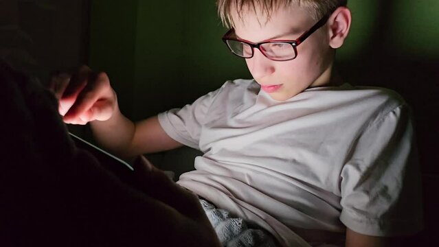 Teenager watches something shocking on mobile phone or tablet. Teenager at night and social networks