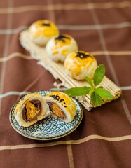 Portion of delicious oriental egg yolk cakes on wooden sticks