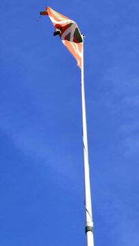 Low-angle view of Basque country flag waving against the blue sky
