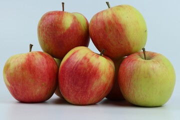 Closeup shot of a group of apples on a blue background.