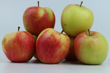 Closeup shot of a group of apples on a blue background.