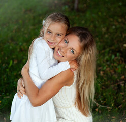 Portrait of a happy mother and daughter hugging in the park.