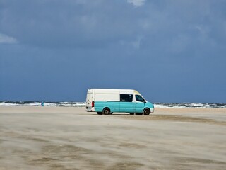 Van on the beach under a gloomy sky