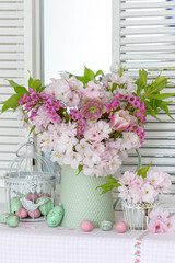 Oster-Arrangement mit Blumenstrauß mit Blüten der Japanischen Säulenkirsche, Lenzrose, Tulpe,...