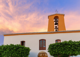 The Church of Santa Gertrude in Santa Gertrudis de Fruitera, Ibiza, gleams under sunset sky, with...