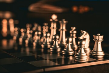 Close-up shot of silver chess pieces on a chessboard