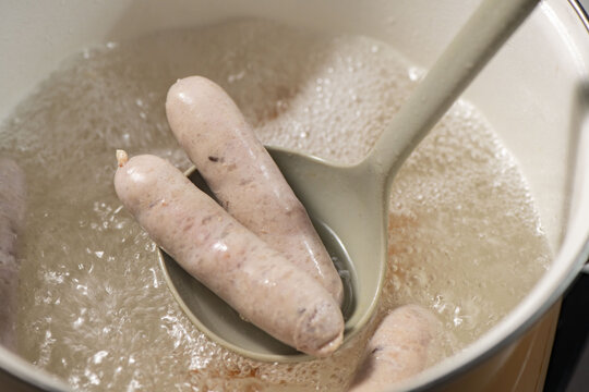 白い鍋でソーセージを茹でるシーン