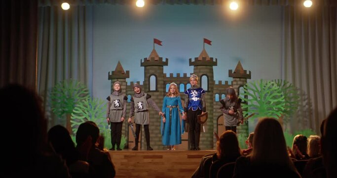 School play depicting medieval times with children in costumes on stage