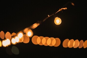 Closeup of a hanging lightbulb at night