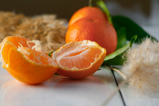 Closeup of fresh, juicy oranges on a white painted wooden surface