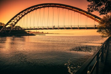 Humber Bay Arch Bridge seen above Lake Ontario reflecting the beautiful sunset sky