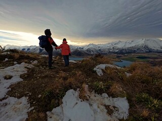 Fototapeta premium Dad and a daughter holding hands near the snowy mountains
