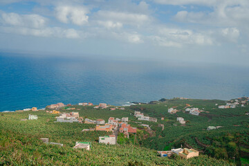 Beautiful view of a village with small houses by the sea under the blue cloudy sky