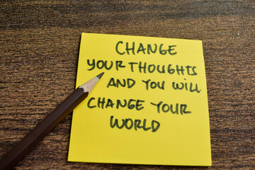 Concept of Change Your Thoughts and You Will Change Your World write on sticky notes isolated on Wooden Table.