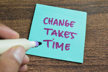 Concept of Change Takes Time write on sticky notes isolated on Wooden Table.