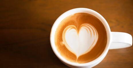 Hot latte art coffee cup on wooden table