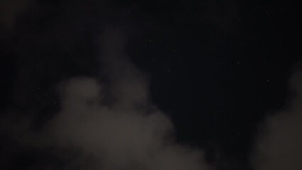 Gray clouds floating in the air against the empty dark black night sky