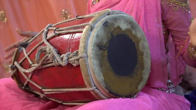 Closeup of female hands playing a dholak instrument