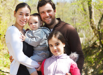Happy young family with daughters outdoors