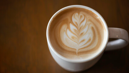 Hot latte art coffee cup on wooden table