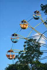 A colorful Ferris wheel against a clear blue sky. Summer fun in the fresh air.