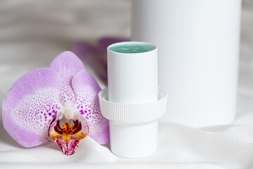 Natural liquid laundry detergent with a floral scent on a background of satin fabric.