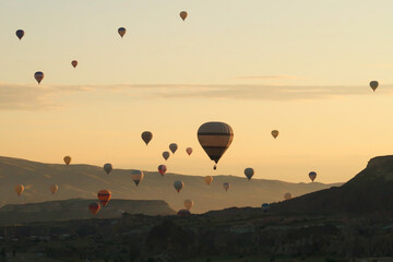 Many colorful hot air balloons over the landscape of the Red Valley, Rose Valley about to land next...