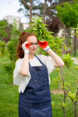 Side view of female florist standing, putting on glasses in garden. Concept of taking care of nature.