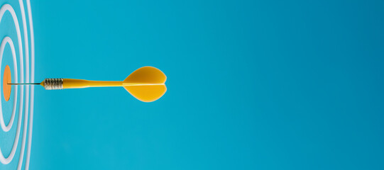 
Darts, a yellow dart with a white ring on a blue background and a target in the style of a business goal concept