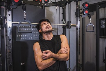 A man in extreme pain clutches his arm. Suffering from a partial or complete bicep tear. Example of...