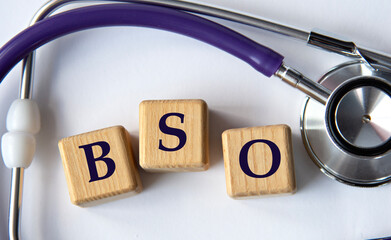 Cubes with the abbreviation BSO on the background of a stethoscope.