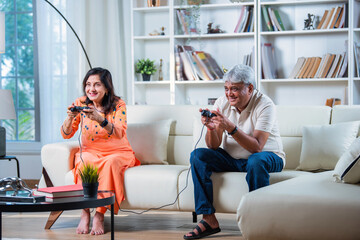 Happy Indian asian matured couple having fun, playing video game together.