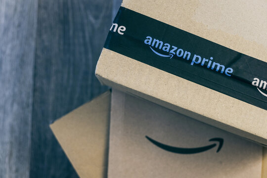 Boxes with Amazon logo on the floor. Order on delivery. Christmas gifts in cardboard box ready to be opened. Amazon Prime priority delivery E-commerce, shop on line concept Milan, Italy - October 2021