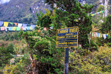 Signpost in the village Ghunsa, Nepal, at the Thango river showing direction to Khambachen (Kangpachen) on the way to the Kanchenjunga Base Camp on the Kanchenjunga base camp trek and  Great Himalaya 