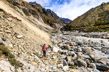 Sherpa guide is crossing a dangerous landslide section on the Kanchenjunga Base Camp Trek between Khambachen (aka Khangpachen or Kambachen) and Lhonak in the Himalaya Mountains, Nepal - 783681378