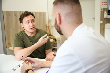 Obraz premium Patient complaining of upper arm pain to physician during consultation