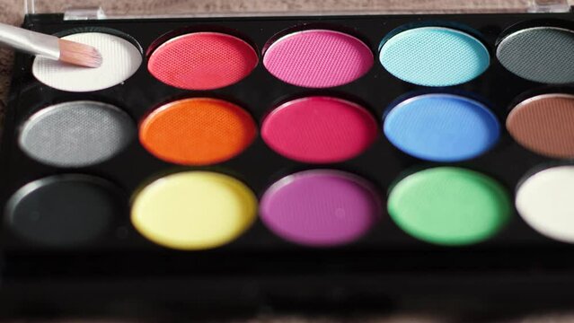 close-up brush and paints for makeup or face painting. the artist paints the face with makeup. makeup paint palette