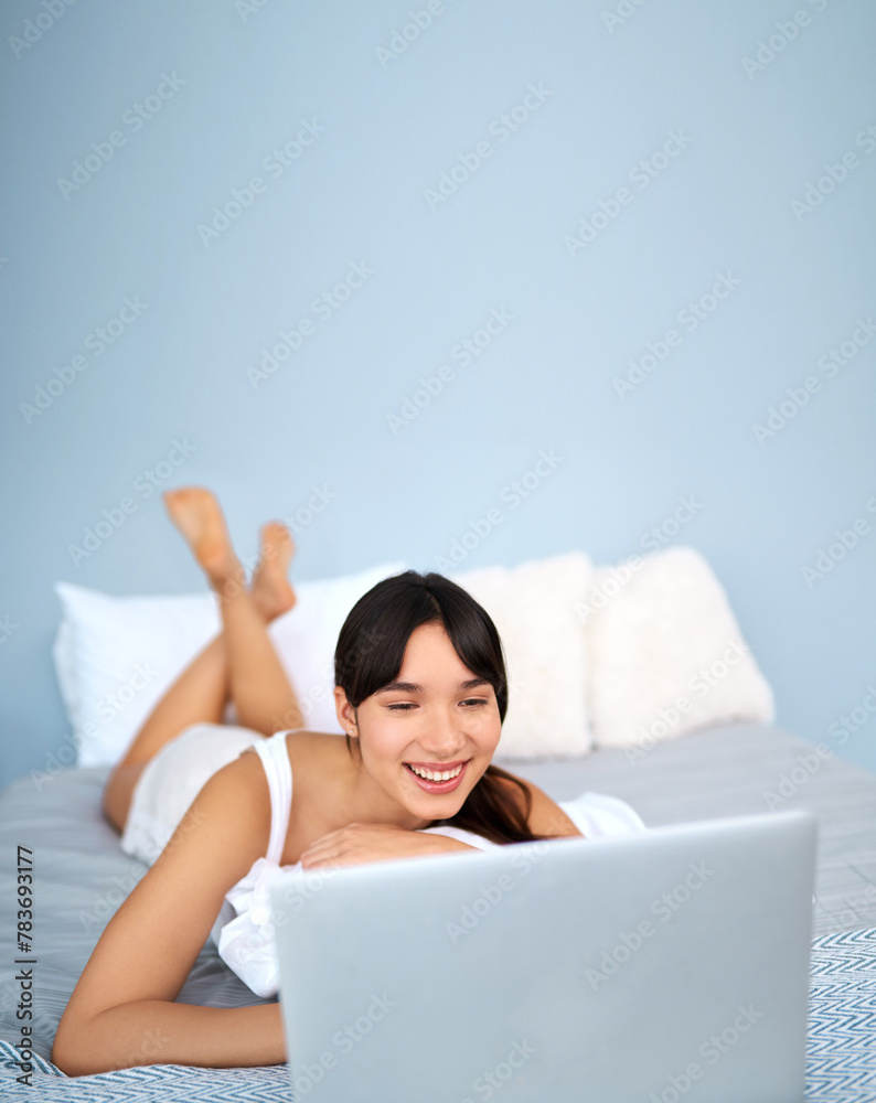 Wall mural Woman, home and happy with laptop in bed for streaming movies and series on website. Female person, smile and online with technology for internet, communication and entertainment in bedroom.