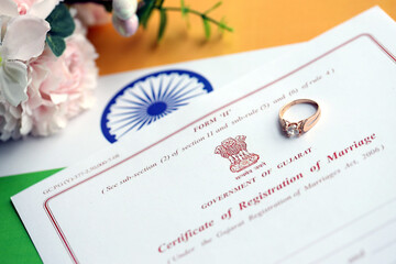 Indian Certificate of registration of marriage blank document and wedding ring on flag close up