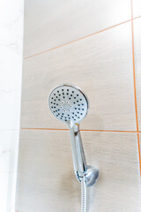 A close up of a plumbing fixture, the shower head, in a bathroom