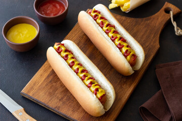 Hot dogs with grilled sausages, ketchup and mustard. Fast food.