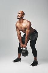 Black man, heavy and kettle bell in studio, struggle and progress for workout or training. Male...