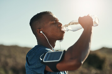 Black man, drink water and music in outdoors for running, thirst and hydrate on sports break. Person, profile and mineral liquid in bottle for nutrition, athlete and phone app for streaming song - obrazy, fototapety, plakaty