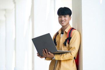 Confident Male Student with Laptop at School