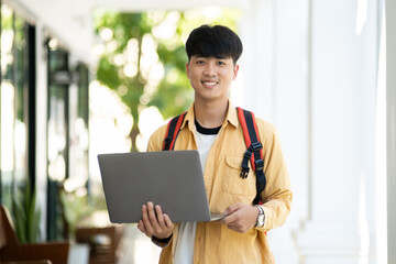 Confident Male Student with Laptop at School